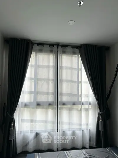 Cozy bedroom with elegant dark curtains and soft natural light