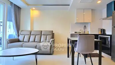 Modern living room with sleek furniture and open kitchen layout in a stylish apartment.