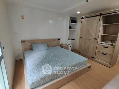 Cozy bedroom with wooden furniture and sliding wardrobe doors, perfect for a serene retreat.