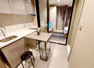 Modern compact kitchen with sleek design and open layout leading to cozy living area.