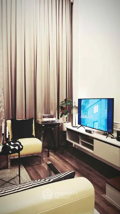 Modern living room with stylish furniture and large TV, perfect for relaxation.