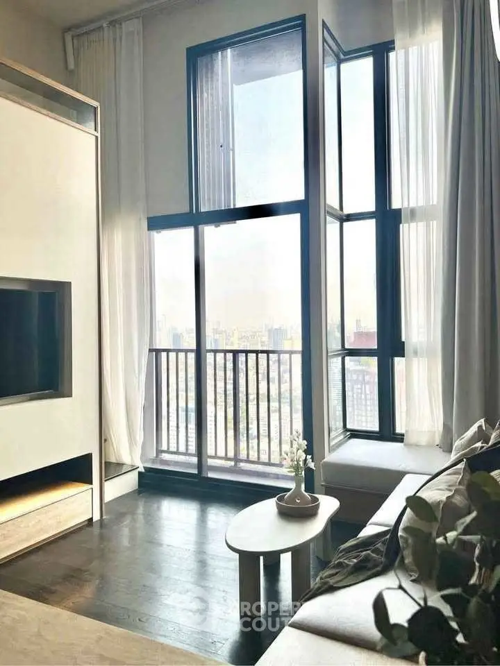 Modern living room with floor-to-ceiling windows and stunning city view.