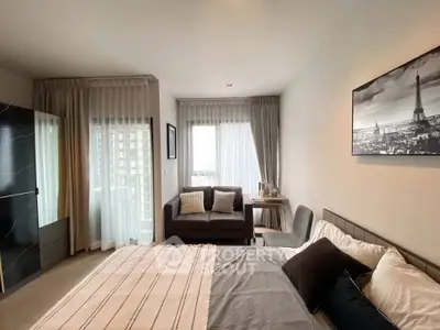 Modern bedroom with stylish decor and city view, featuring a cozy sofa and elegant artwork.