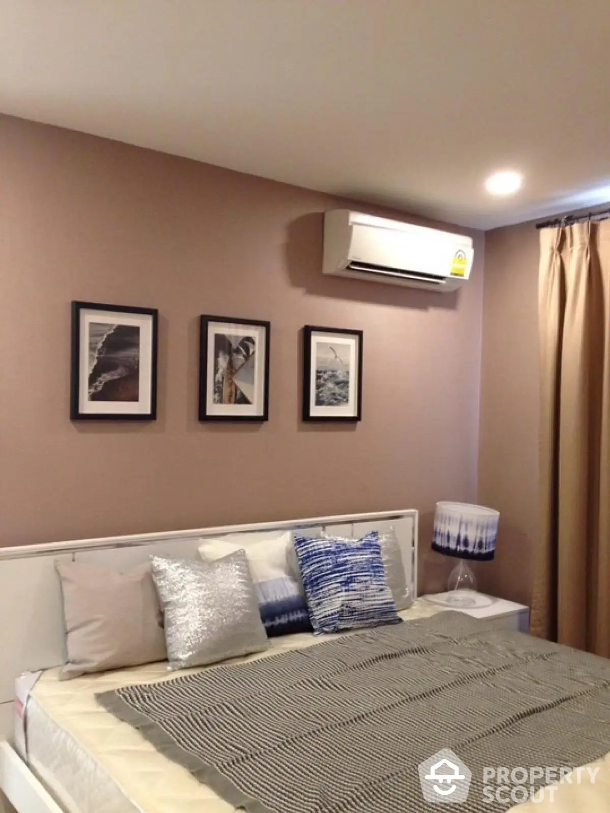 Cozy bedroom with modern decor and air conditioning, perfect for relaxation.