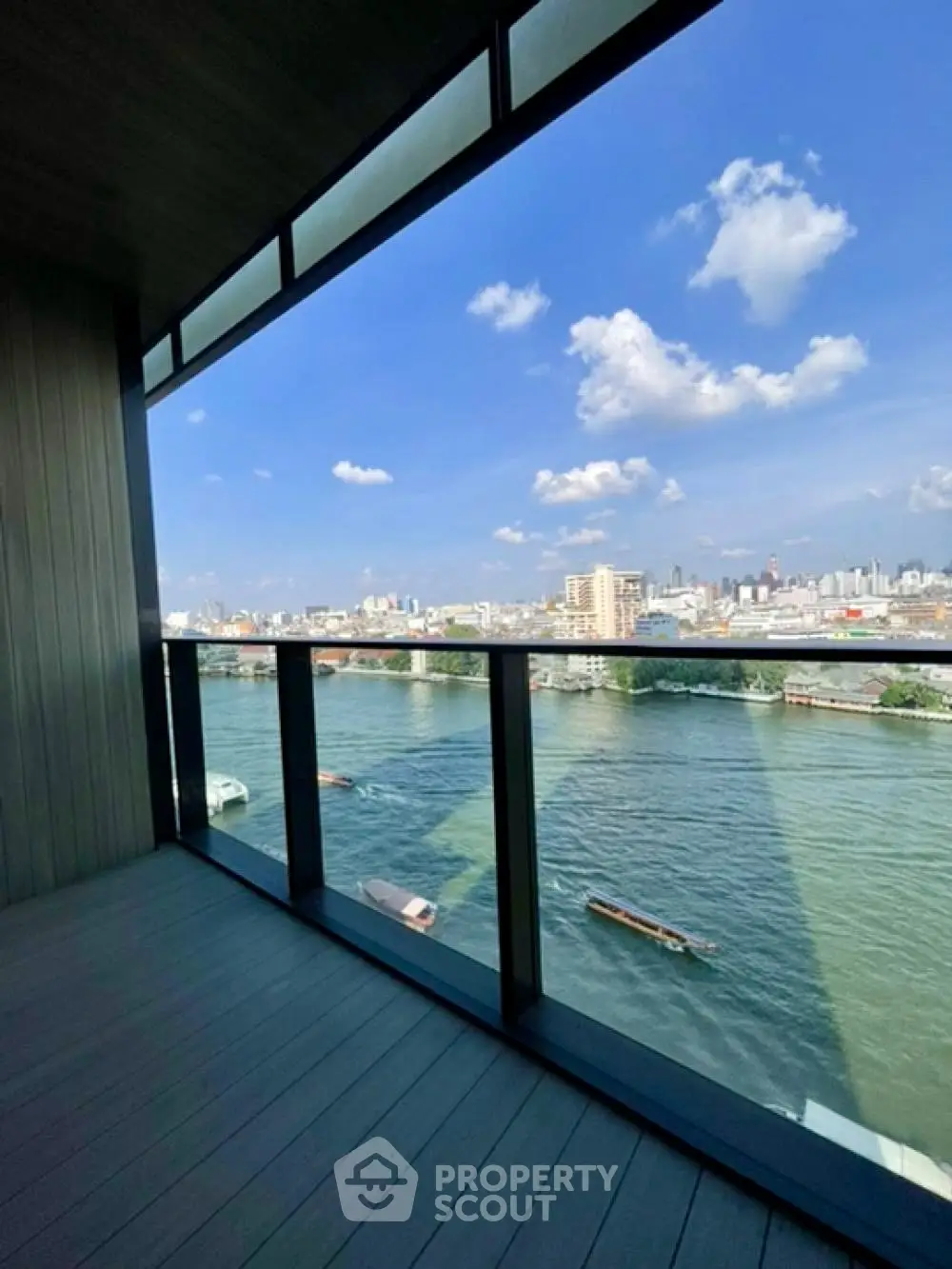 Stunning river view from a modern balcony with glass railing, perfect for relaxation.