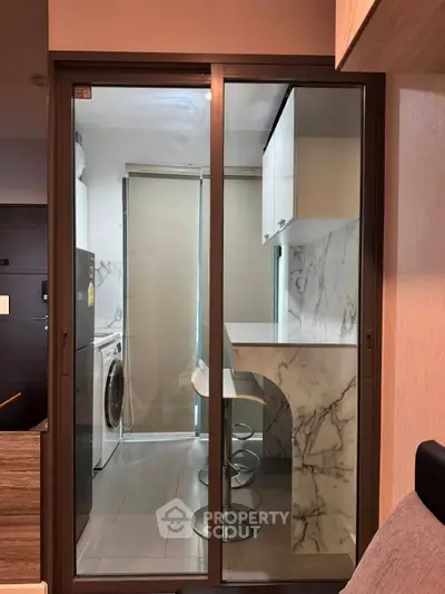 Modern compact kitchen with marble countertops and washing machine