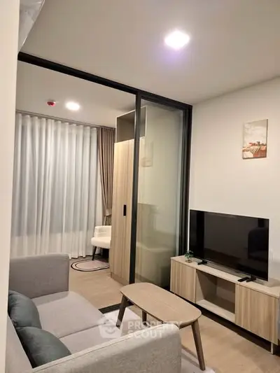 Modern living room with sleek furniture and TV, featuring a cozy ambiance and stylish decor.