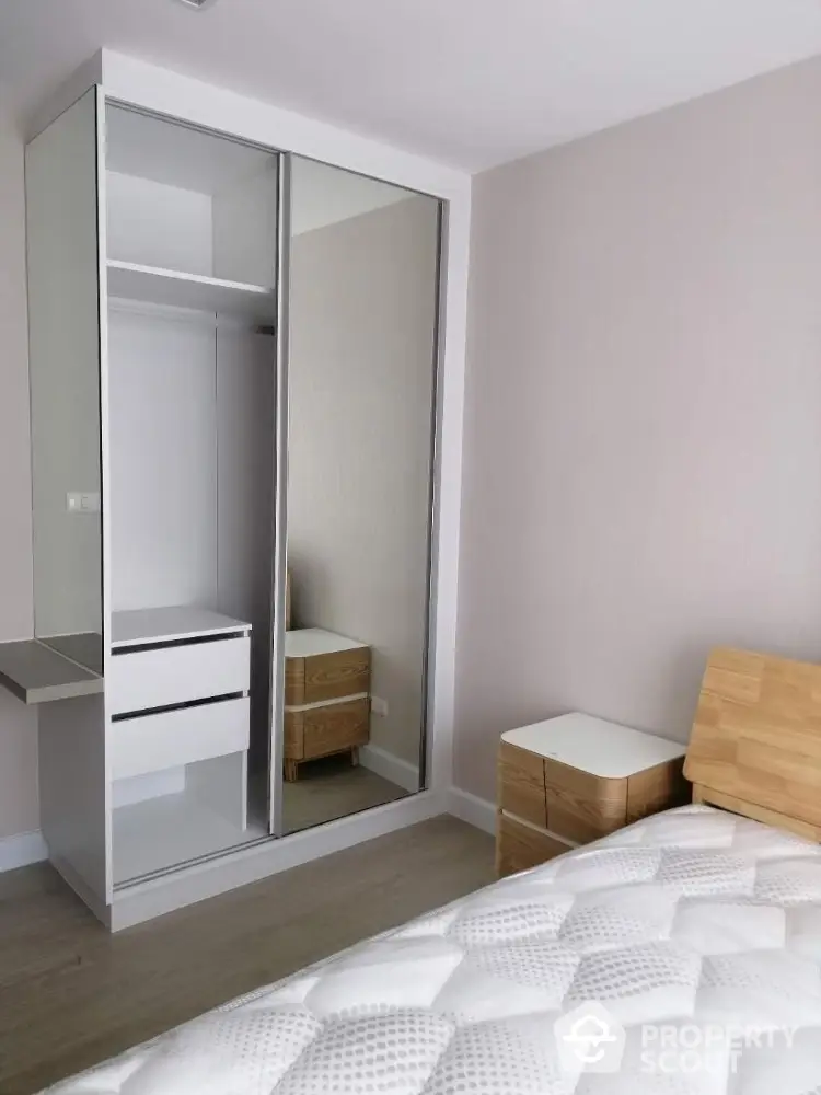 Modern bedroom with mirrored wardrobe and wooden furniture