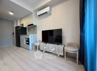 Modern living room with sleek kitchen, air conditioning, and stylish decor in a contemporary apartment.