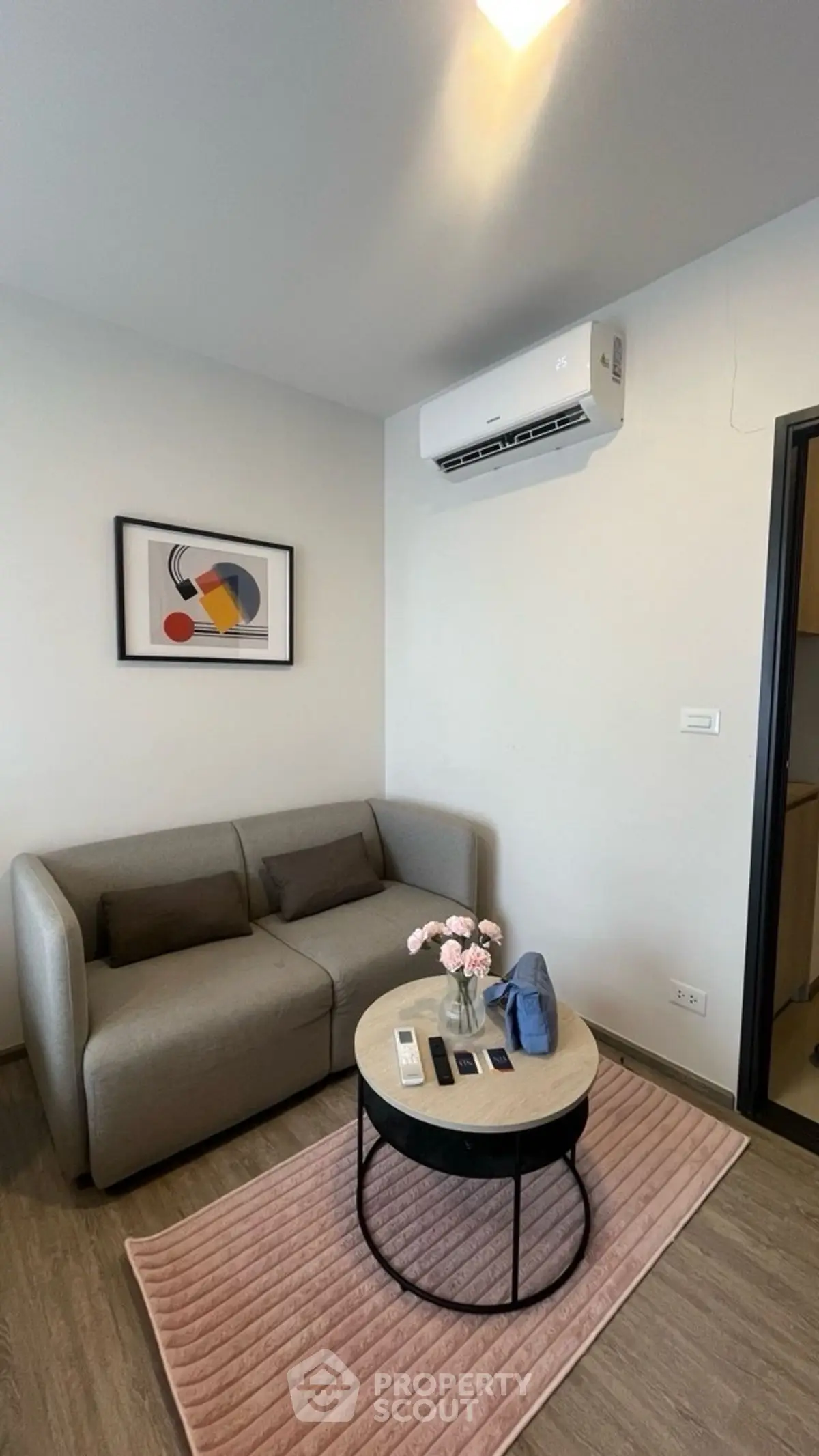 Cozy living room with modern sofa and air conditioning, perfect for relaxation.