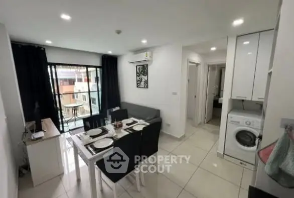 Modern living room with dining area and washing machine, bright and stylish interior.