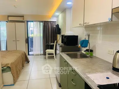 Modern studio apartment with open kitchen and cozy bedroom area, featuring sleek appliances and natural light.