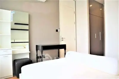 Bright and modern bedroom with sleek furniture and ample storage space.