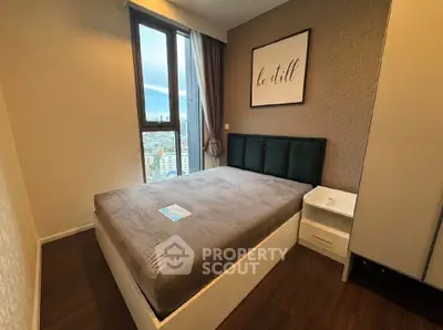 Modern bedroom with city view, featuring a cozy bed and stylish decor.