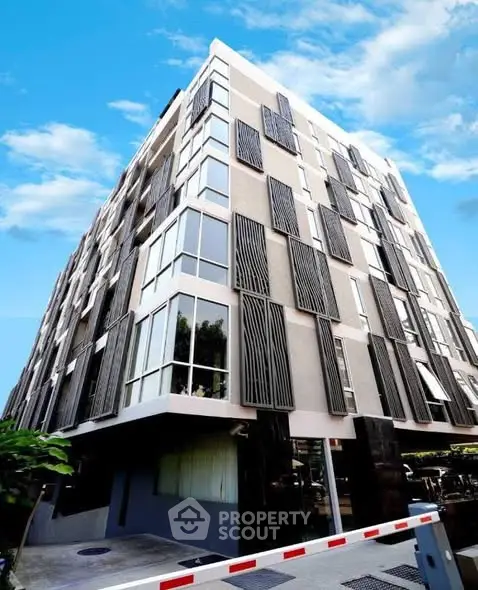 Modern architectural building with unique facade design and large windows under a clear blue sky.