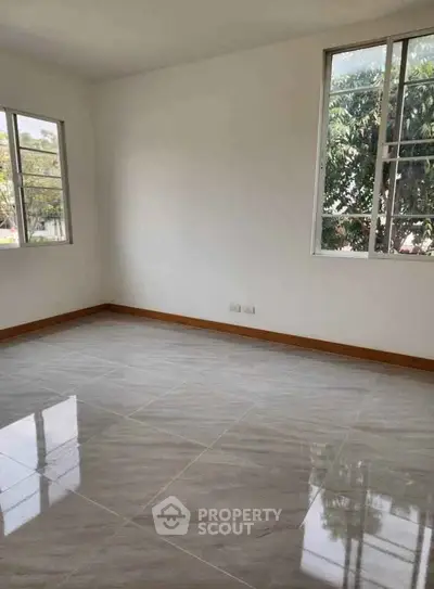 Bright empty room with large windows and glossy tiled floors, perfect for customization.