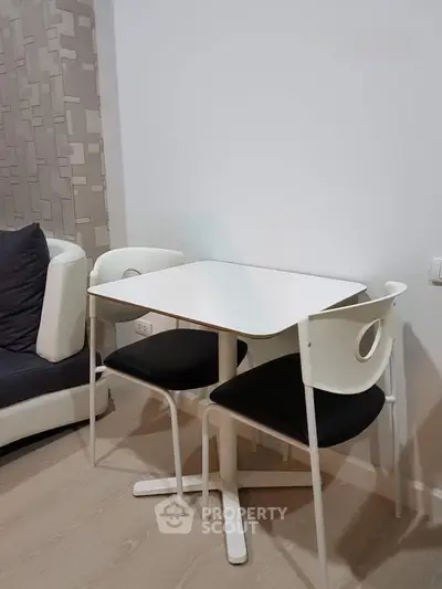 Modern compact dining area with stylish white table and chairs in cozy living space.