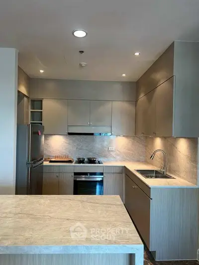 Modern kitchen with sleek cabinetry and built-in appliances in a contemporary apartment.