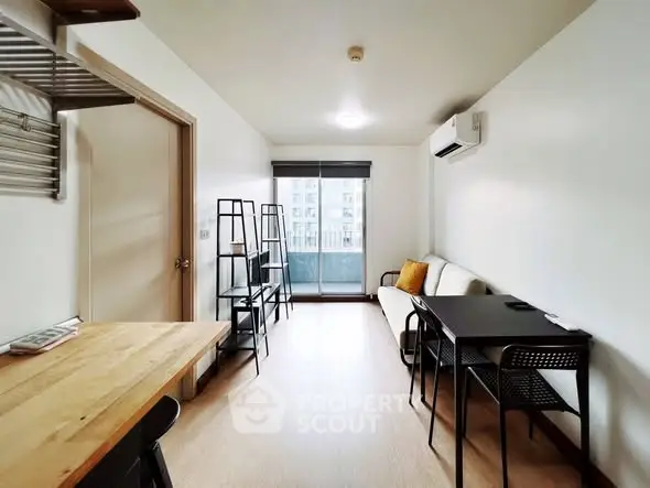 Modern living room with balcony access, featuring sleek furniture and natural light.