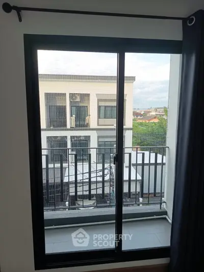 Modern apartment balcony with sliding glass door and urban view
