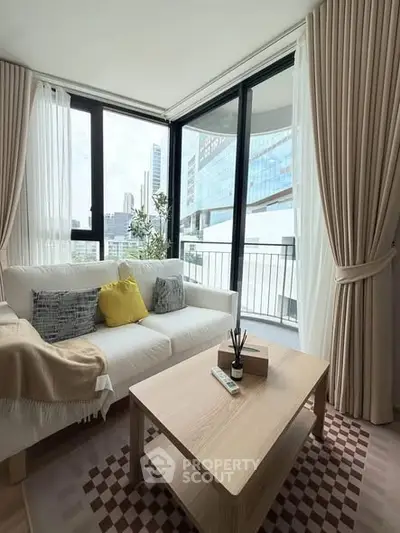 Modern living room with large windows and city view, featuring cozy sofa and stylish decor.