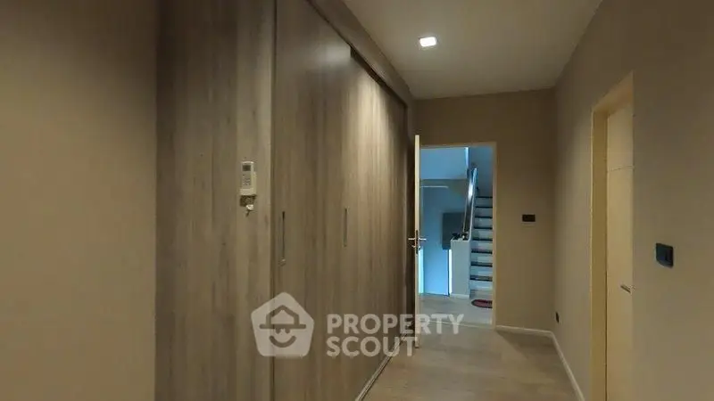 Spacious hallway with wooden flooring and built-in storage