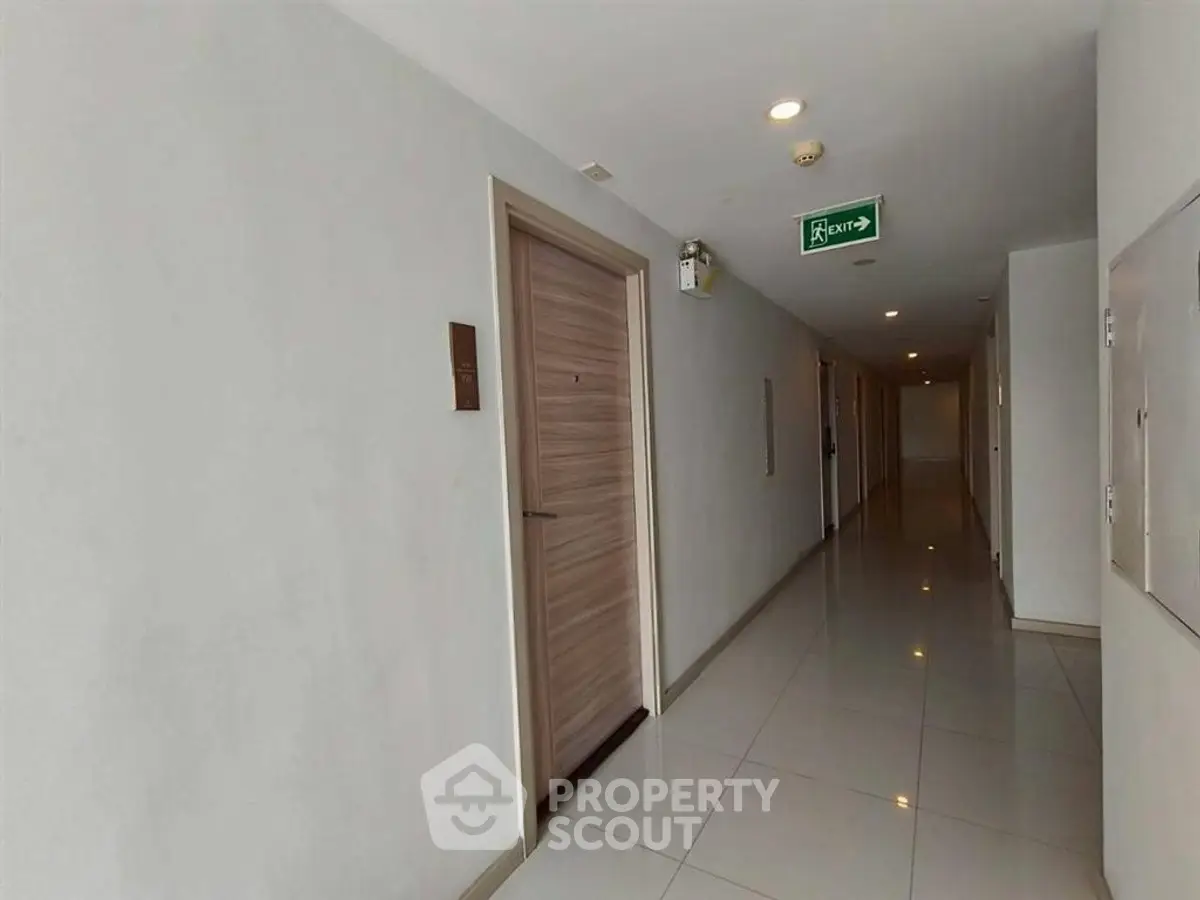 Modern apartment corridor with sleek design and polished tile flooring.