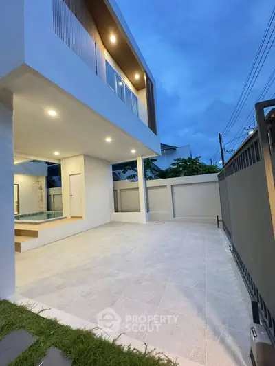 Modern two-story home with sleek architecture and spacious outdoor patio at dusk.
