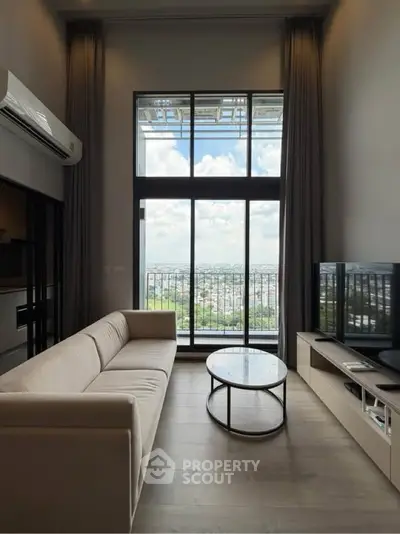 Modern living room with large window offering stunning city view, featuring sleek furniture and neutral tones.