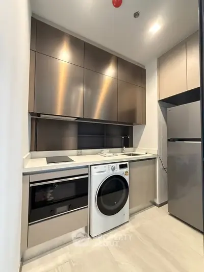Modern kitchen with sleek cabinets, built-in oven, and washing machine
