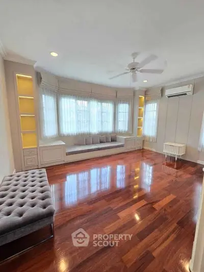 Spacious living room with elegant hardwood floors and built-in seating, perfect for relaxation.