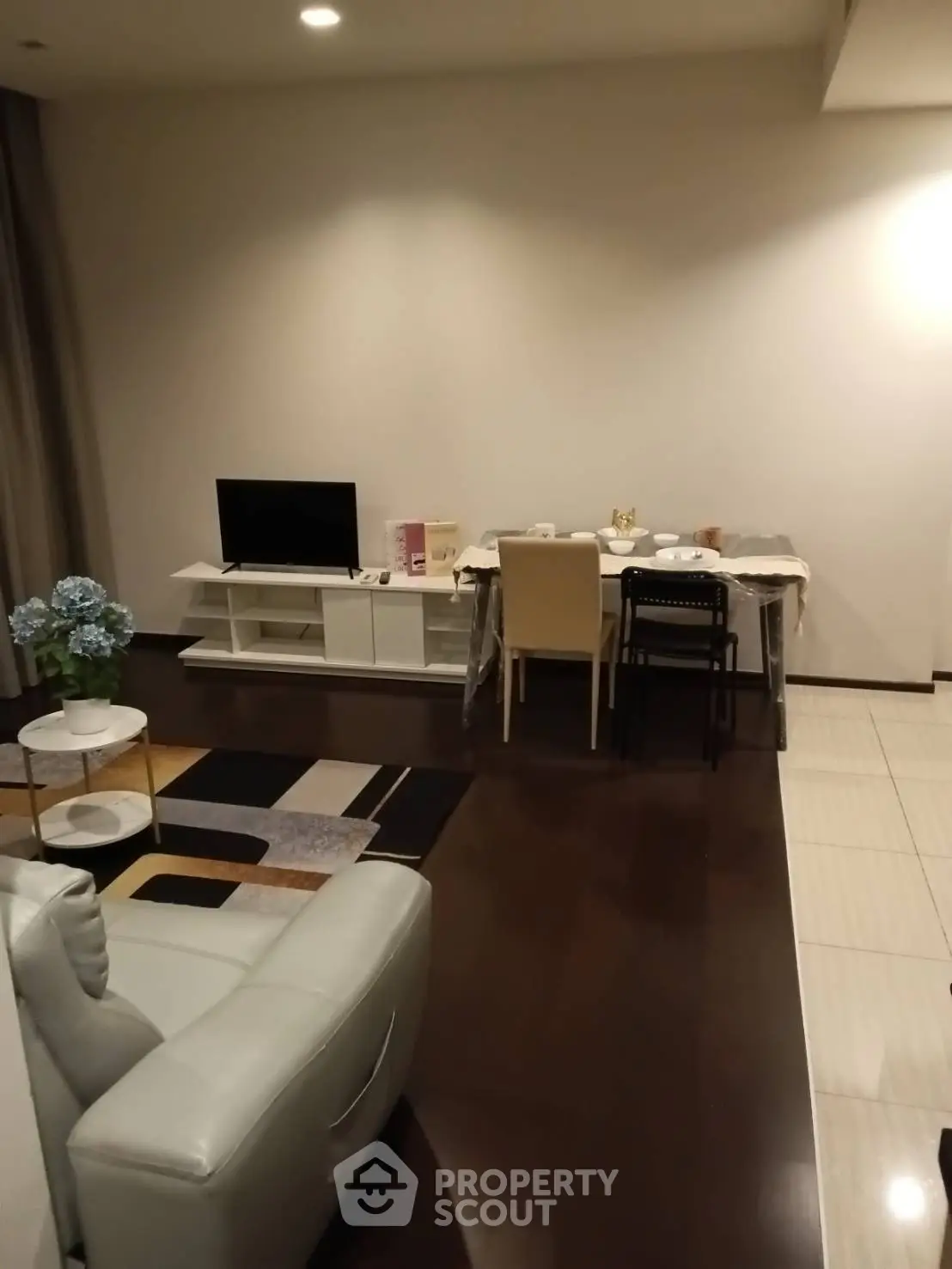 Modern living room with sleek furniture and dining area, perfect for cozy gatherings.