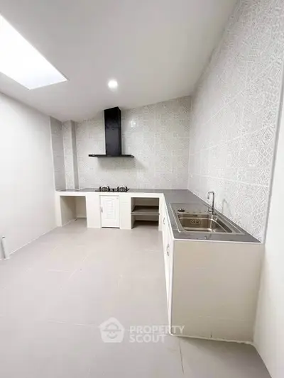 Modern kitchen with sleek design and gas stove, featuring stylish tile backsplash and ample counter space.