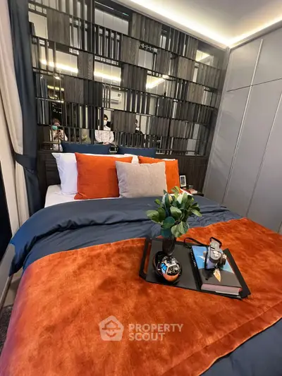 Luxurious bedroom with modern decor and stylish mirrored wall feature.