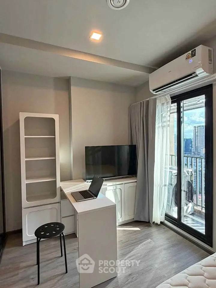 Modern living room with balcony view, featuring sleek furniture and natural light.