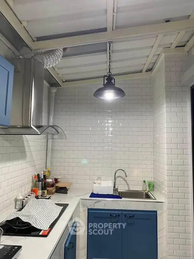 Modern kitchen with blue cabinets, white subway tiles, and sleek appliances.