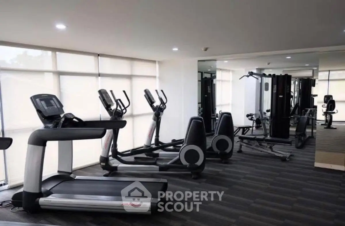 Modern gym with state-of-the-art fitness equipment and large windows for natural light.