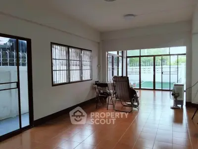 Spacious living room with large windows and outdoor access, perfect for relaxation and entertaining.