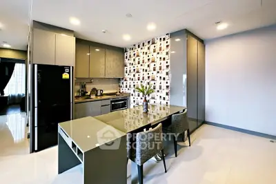 Modern kitchen with sleek cabinetry and stylish dining area in contemporary apartment.