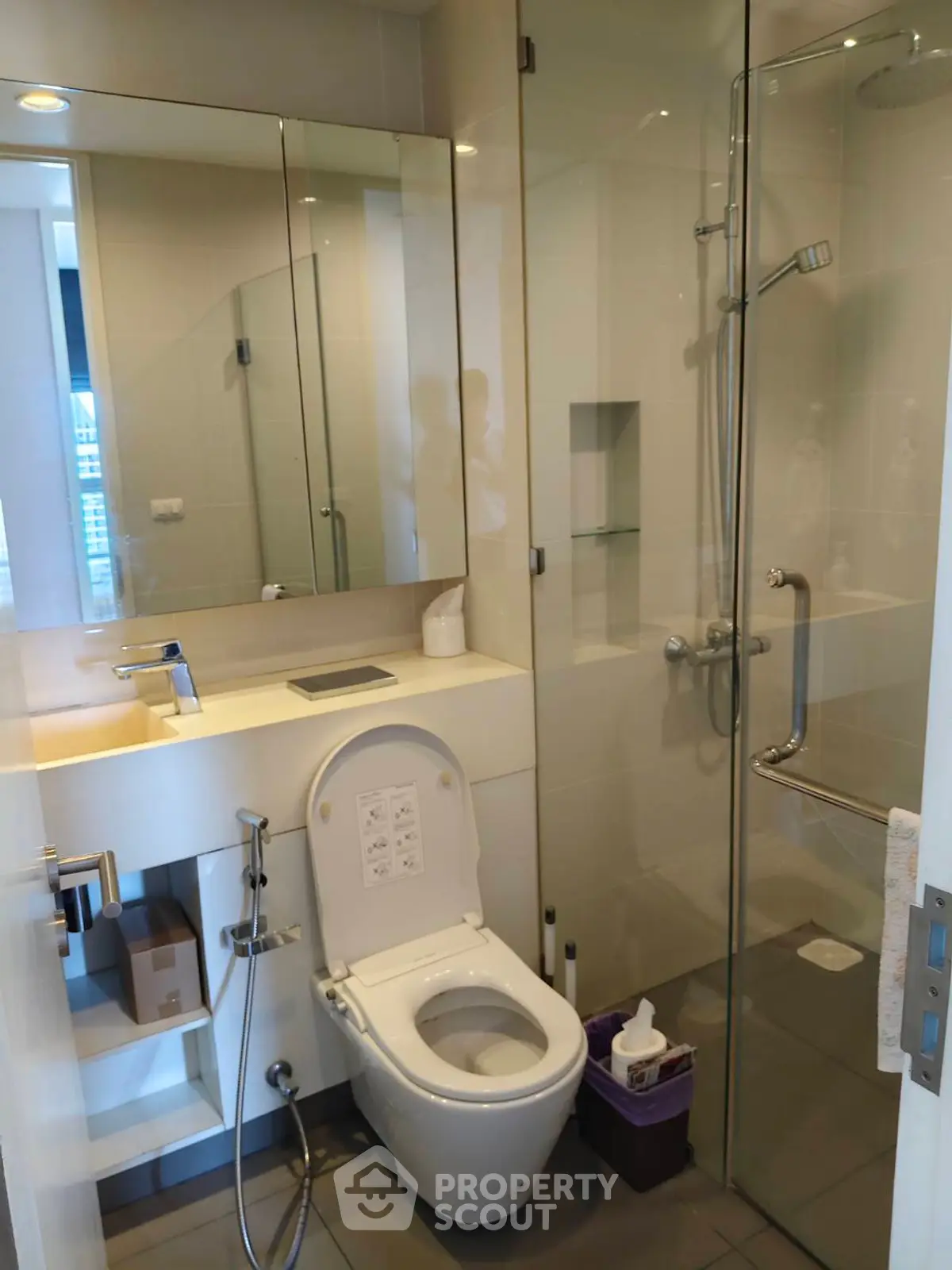 Modern bathroom with glass shower and sleek fixtures in a contemporary apartment.