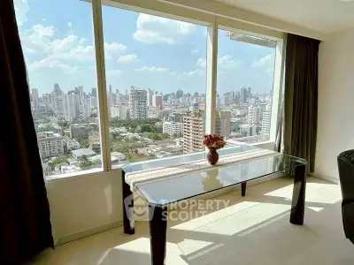 Stunning cityscape view from a modern high-rise apartment with floor-to-ceiling windows.