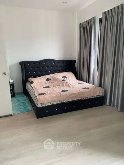 Elegant bedroom with stylish bed and curtains, featuring modern decor and natural light.