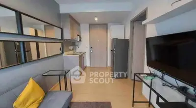 Modern living room with sleek furniture and open kitchen layout in a stylish apartment.