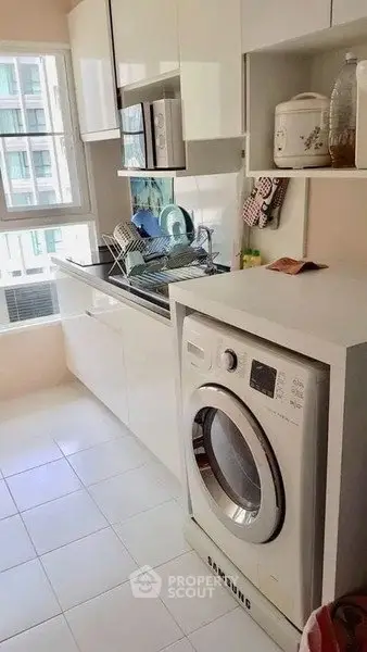 Modern kitchen with washing machine and sleek white cabinetry