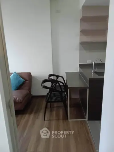 Modern apartment interior with sleek kitchen and cozy living area featuring stylish furniture.