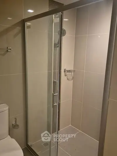 Modern bathroom with sleek shower enclosure and neutral tiles