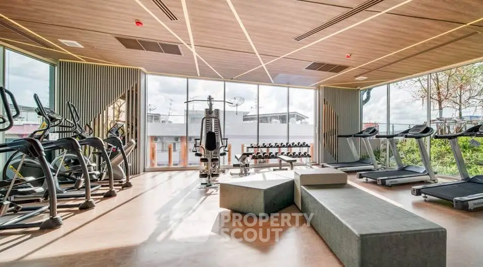 Modern gym with state-of-the-art equipment and large windows offering natural light.