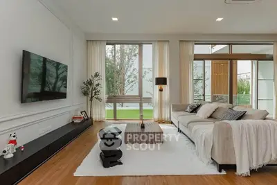 Luxurious modern living room with elegant decor and large windows offering natural light.