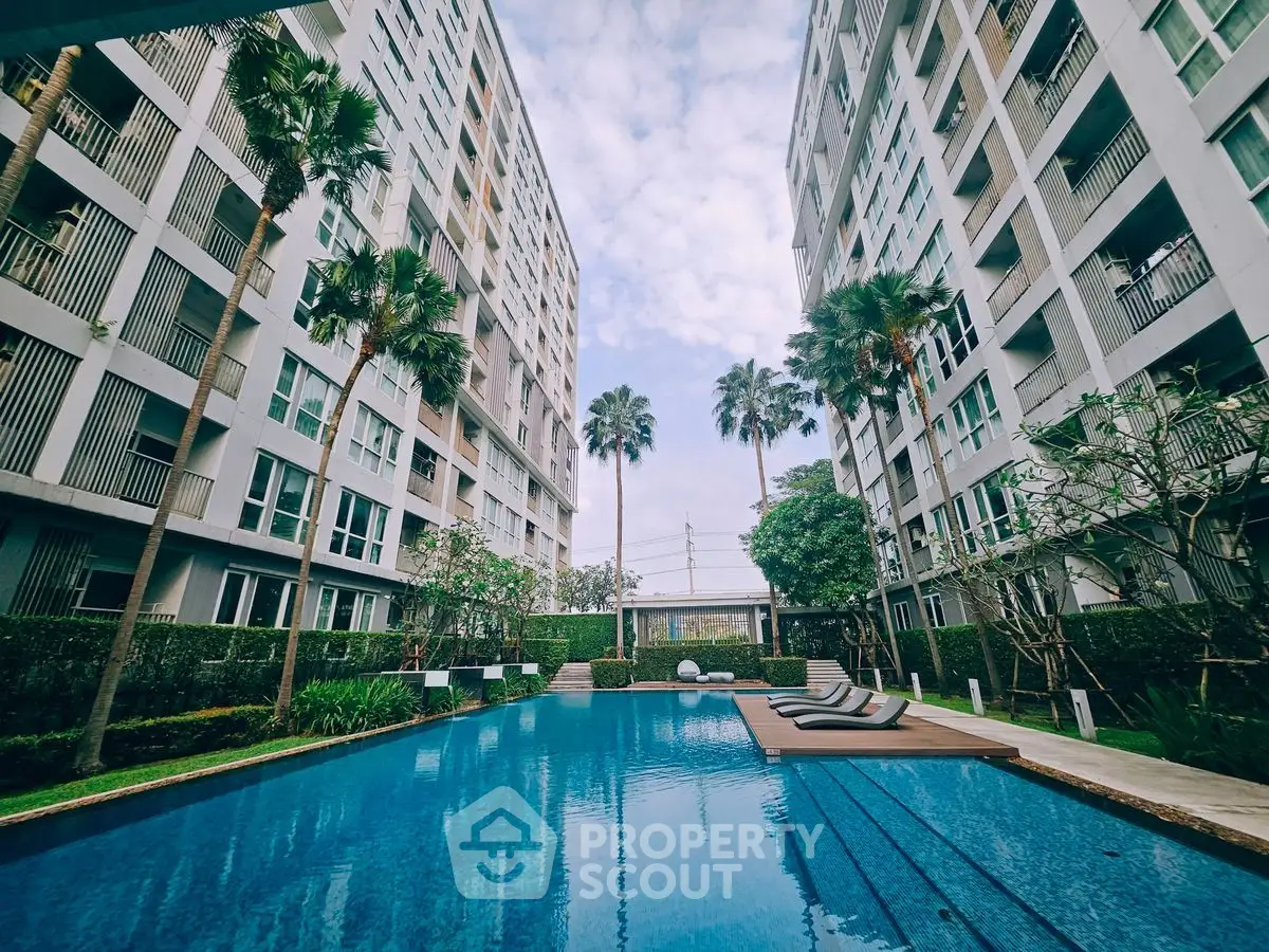 Luxurious apartment complex with stunning pool and palm trees, perfect for modern living.