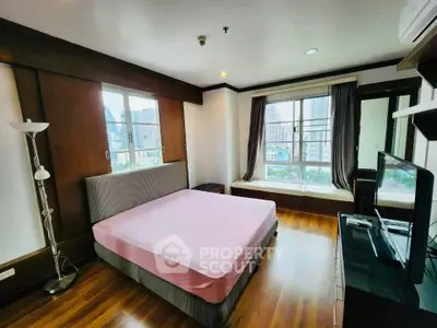 Spacious bedroom with city view, featuring large windows and modern furnishings.